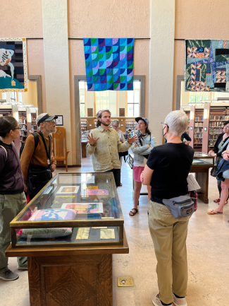An artist speaking to a small group about the art displayed around them