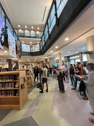 An artist discussing the art in front of a crowd