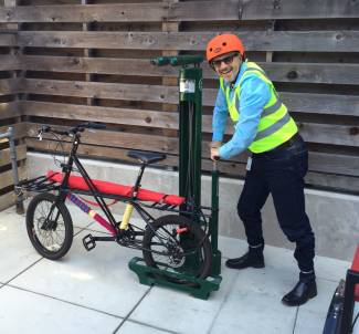Ilan pumping the tire on the Library on Wheels companion bike.