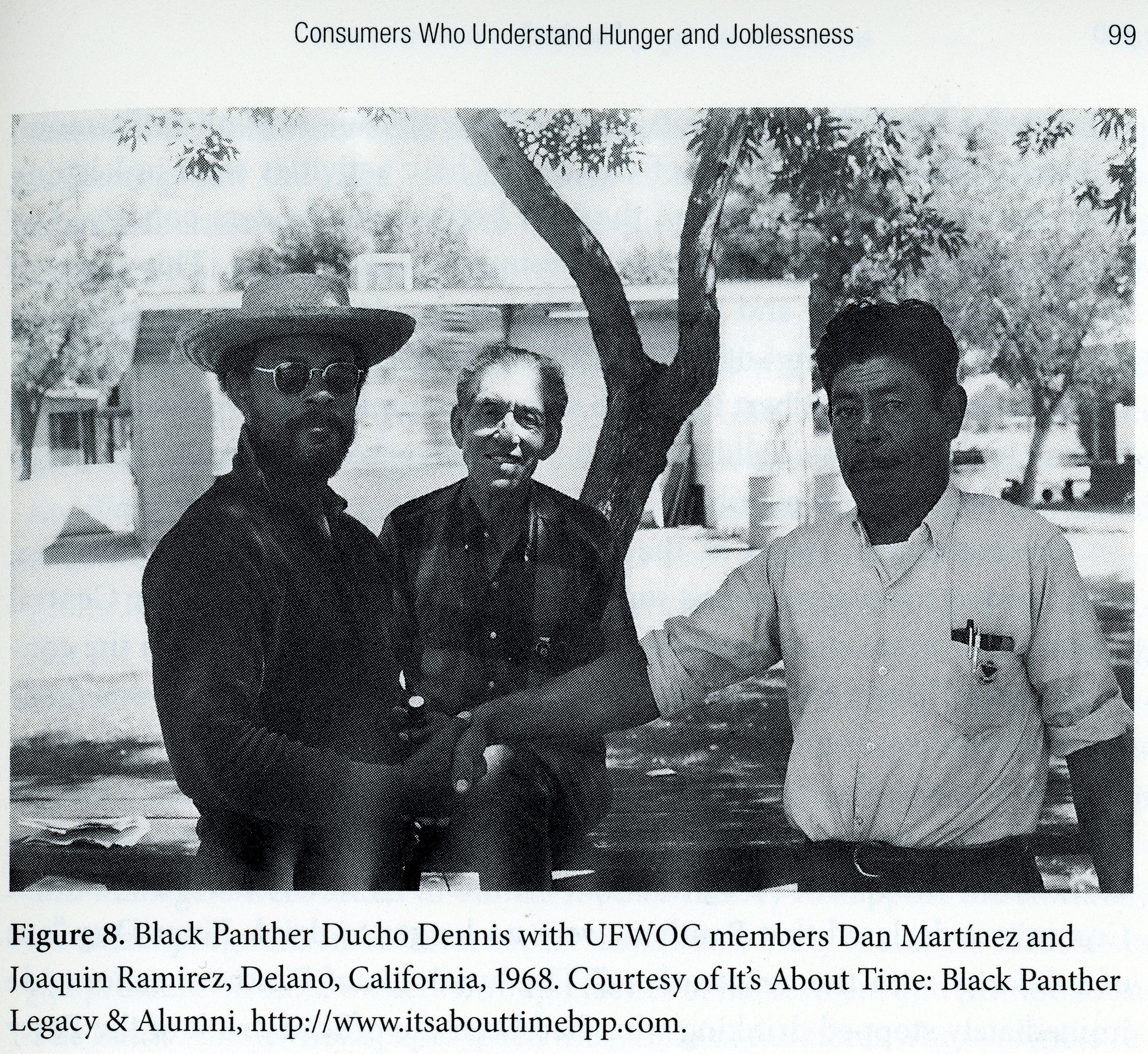 Black and white scan of three men looking at the camera with a farm in the background