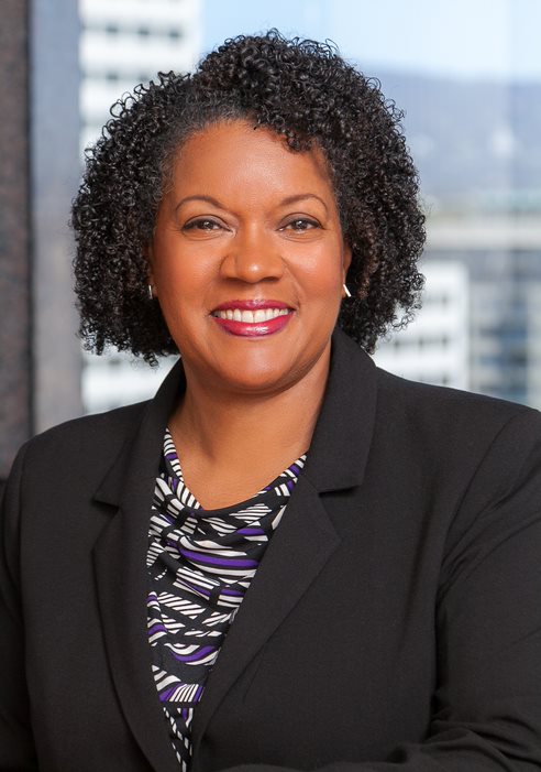 headshot of Trustee Greene in front of a window looking out on a city