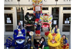 Dragon dancers with colorful costumes posing in front of Central Library 