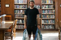 curator standing in central library holding quilt