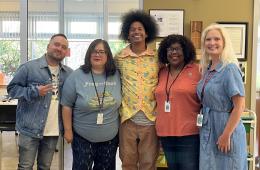 Four Library Staff on Filming Day Smiling with Mychal Threets