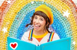 Bri Reads with book and rainbow