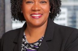 headshot of Trustee Greene in front of a window looking out on a city