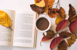 Leaves and a warm drink staged with an open book