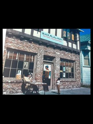 Photo of a brick building and a few people out on the sidewalk
