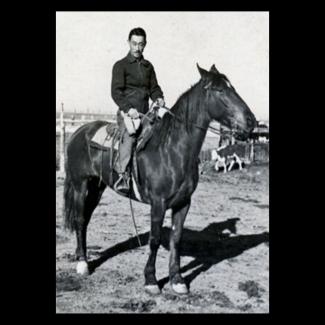 Black and white photograph of a Japanese American man on horseback in the desert
