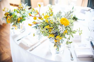 Floral centerpiece on table, dressed in white cloth