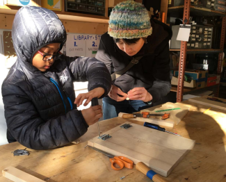Adult woman and child working on a wood project.