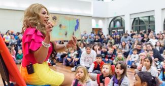 photo of Bella reading to large group of kids