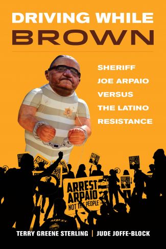 Features a balloon that looks like Joe Arpaio in a prisoner's outfit with with chains around his wrists on orange background.