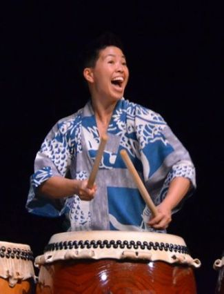photo of Kristy Oshiro smiling and playing taiko