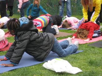 photo of children doing yoga outside wearing coats
