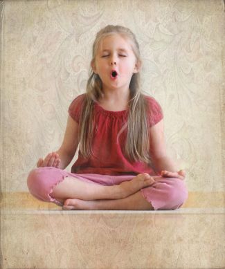 photo of child sitting in lotus pose while chanting