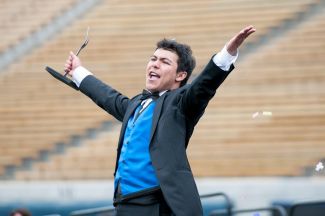 photo of Magical Nathaniel standing in front of bleachers with outstretched arms