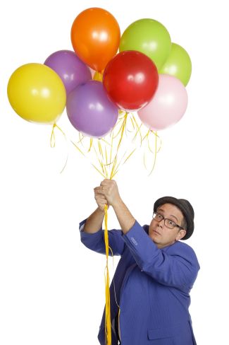 photo of Mike Della Penna holding on to balloons above his head and looking surprised