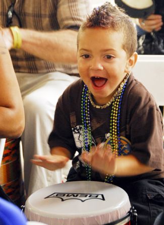 photo of smiling boy playing drum