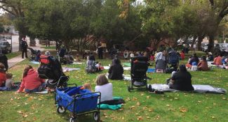 Patrons listen to story time on the lawn at the North Branch Library