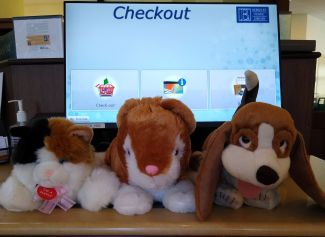 Three stuffed animals at the self checkout machine