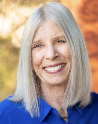 Author Terry Greene Sterling with blue shirt and orange and green background.