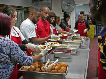 Line of volunteers serving a meal at Bay Area Rescue Mission.