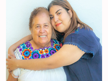 two people presenting as women posing and embracing