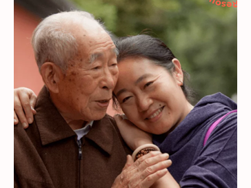 older man and younger adult woman posing together