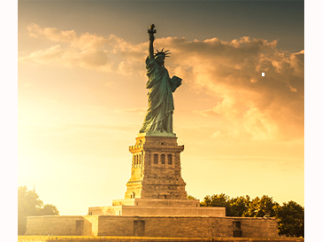 Statue of Liberty against sunset with clouds