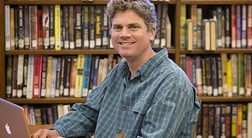 Man using laptop at library.