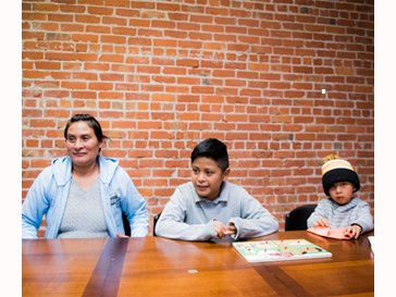 an adult and parent at a table in front of a brick wall