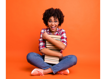 A girl holding a stack of books.