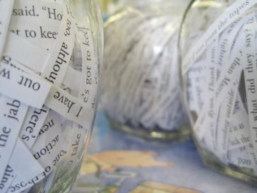 Clear jars filled with shreded paper containing text.